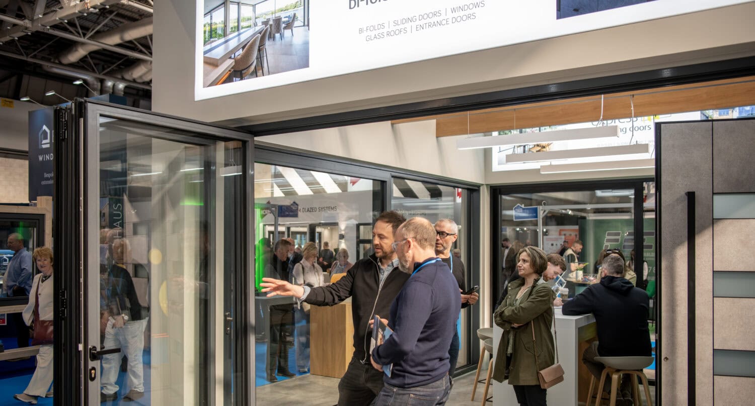 High-quality bi-folding doors showcasing sleek glass panels and aluminium frames at an exhibition.