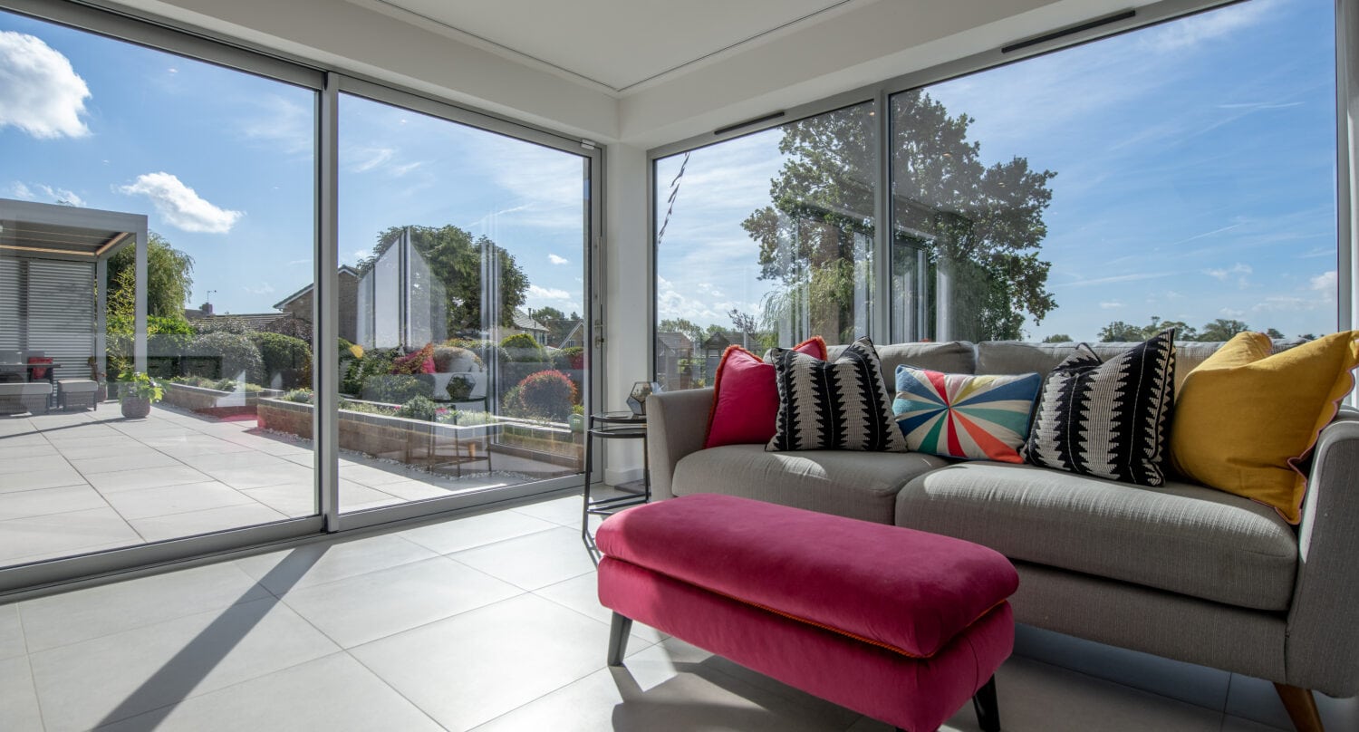 Bi-folding doors opening to a bright conservatory in Firs Drive, Harrogate, showcasing seamless indoor-outdoor living with large glass panels and aluminium frames.