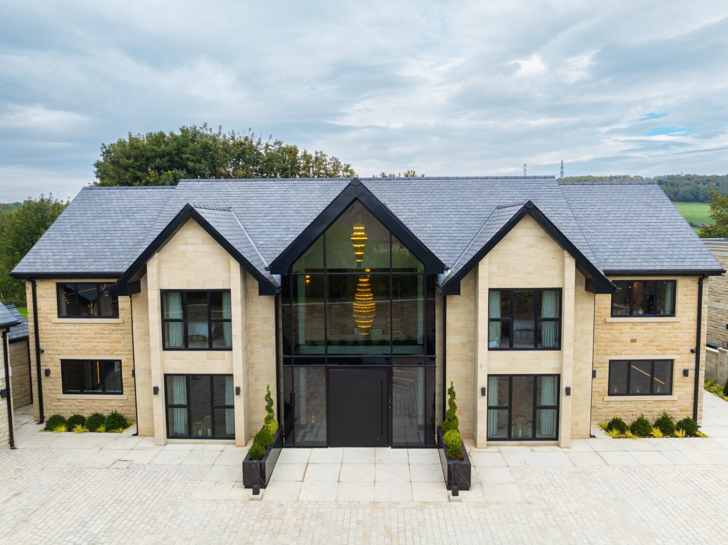 Elegant pivot doors opening to a modern home exterior.
