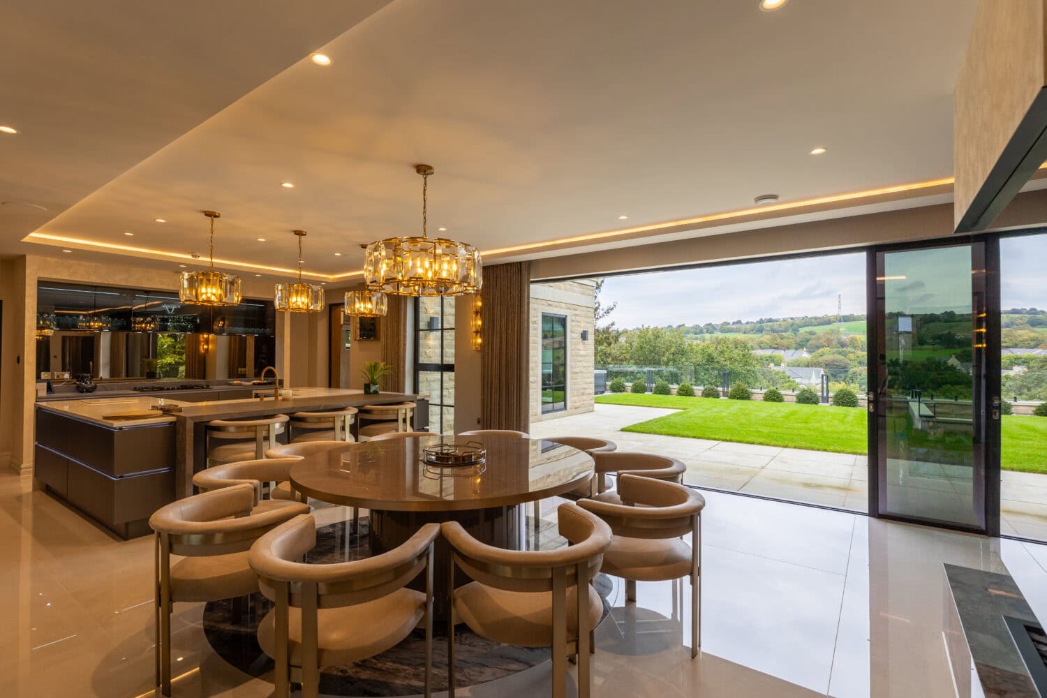 Spacious indoor dining area featuring large glass bi-fold doors that open to a lush outdoor garden, perfect for modern luxury living and seamless indoor-outdoor entertaining.