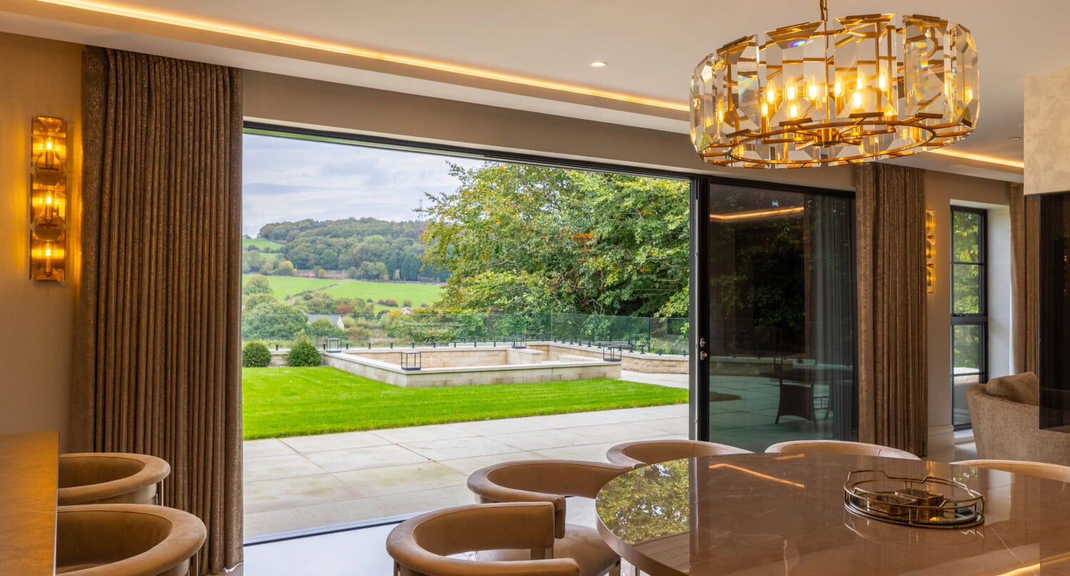 Modern Arlington luxury home with large bi-folding doors opening to scenic outdoor views. Perfect for seamless indoor-outdoor living and stylish home design.