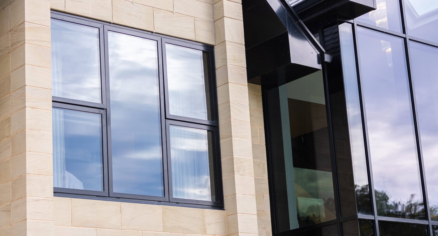 Modern bi-folding doors installed in a luxury development, offering seamless indoor-outdoor living with large glass panels and sleek black frames.