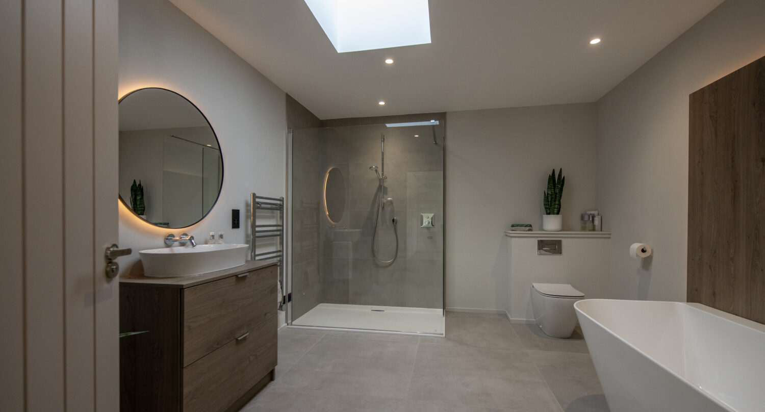 Elegant bathroom featuring large bi-fold doors opening to the garden at Orchard Farm, Crossford, enhancing natural light and outdoor access.