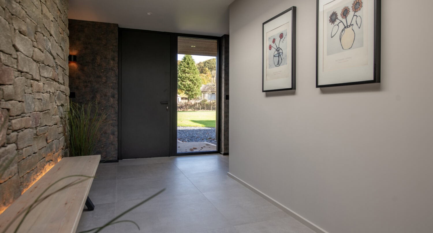 Elegant Orchard Farm entrance featuring large bi-folding doors that open to a scenic garden, combining style and functionality for seamless indoor-outdoor living.