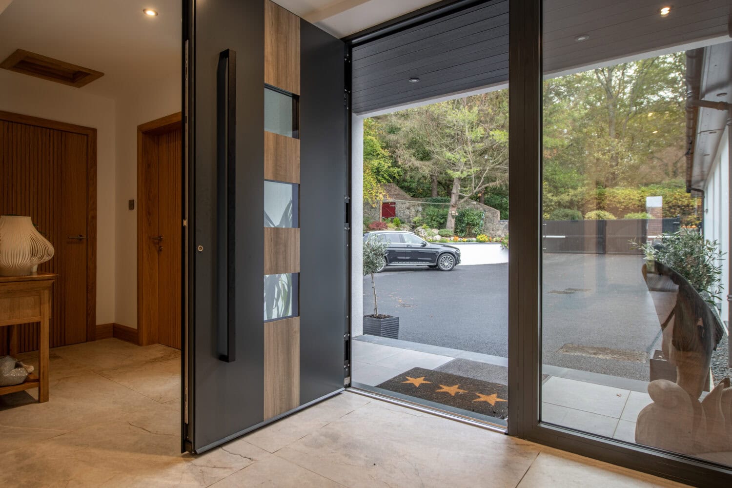 Elegant bi-folding doors opening to the garden, providing seamless indoor-outdoor living space. High-quality aluminium frames with large glass panels enhance natural light and style.