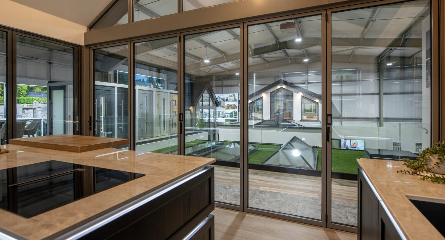 Bi-folding doors with large glass panels in a Glasgow showroom, showcasing sleek design and seamless indoor-outdoor transition. Perfect for enhancing home aesthetics and natural light.