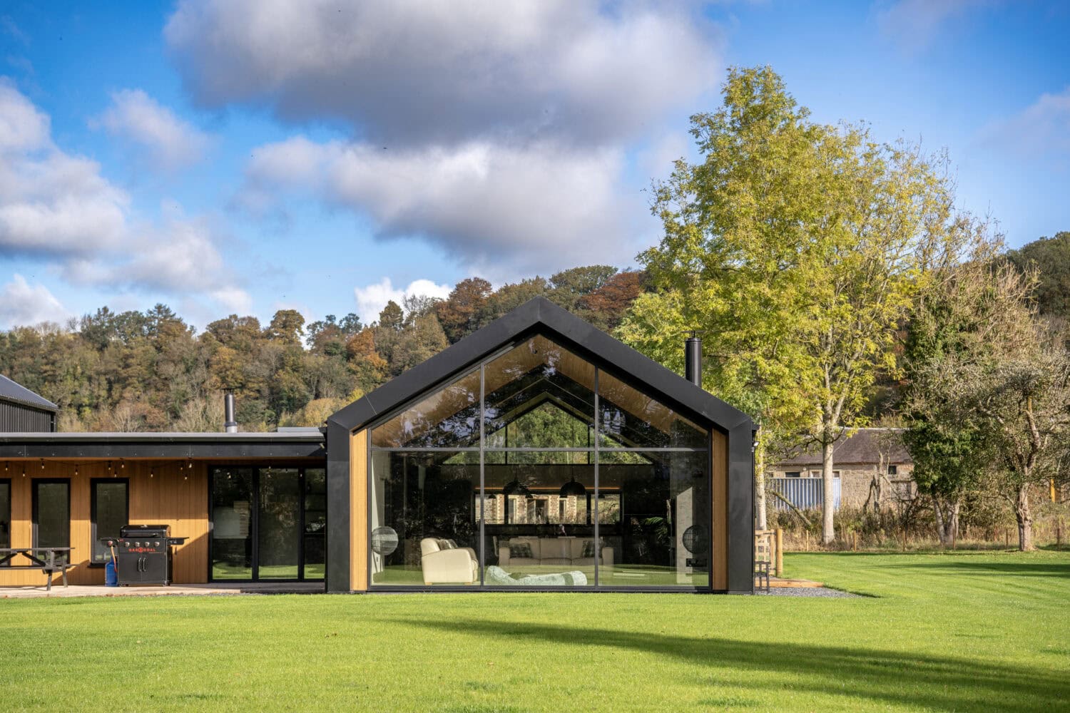 Bi-folding doors at Orchard Farm, Crossford, showcasing seamless indoor-outdoor living with large glass panels and sleek black frames.