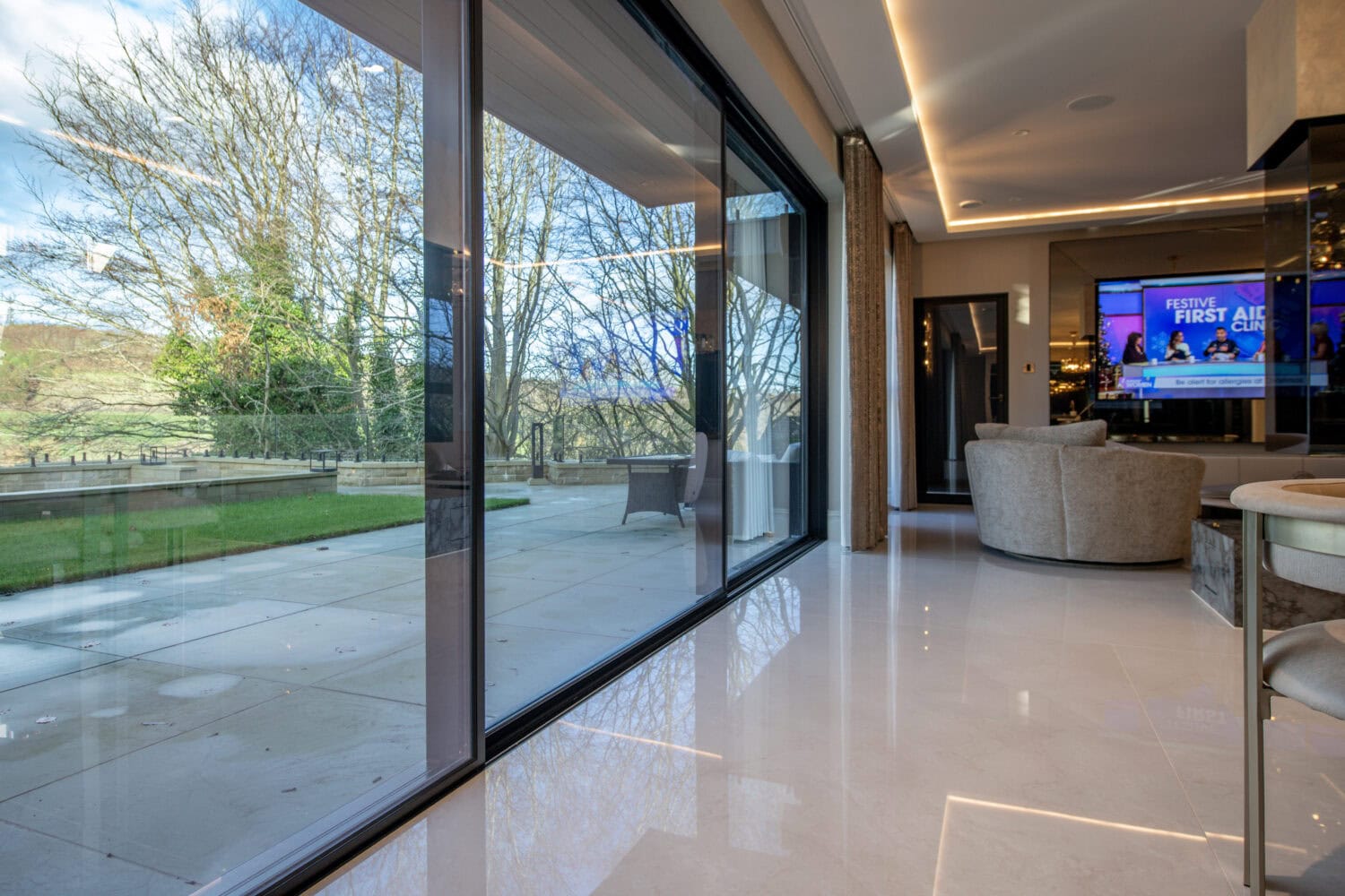High-quality XP Glide bi-fold doors opening to a garden, showcasing sleek design and smooth operation, ideal for enhancing indoor-outdoor living spaces.