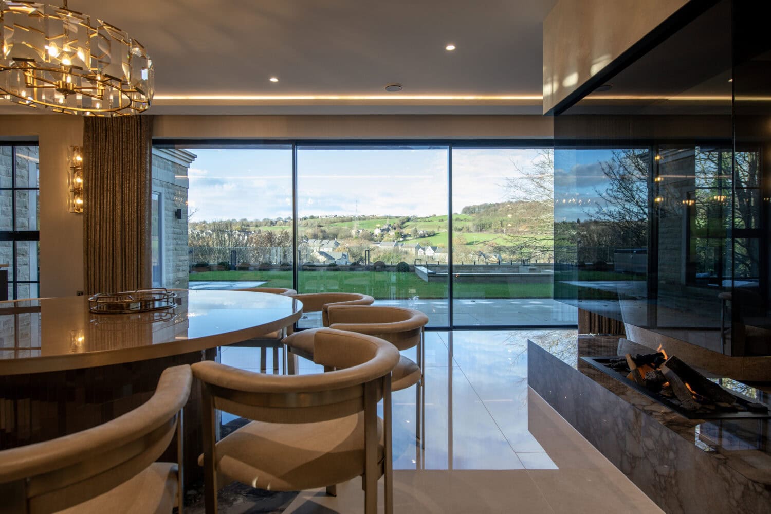 Modern XP Glide bi-fold doors opening to a scenic landscape, enhancing natural light and outdoor views in a contemporary home setting.