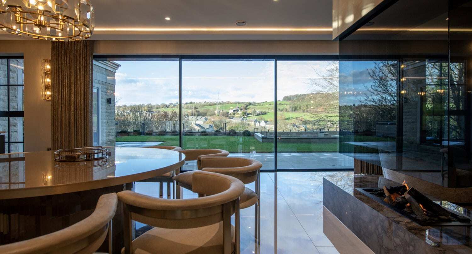 Modern XP Glide bi-fold doors opening to a scenic landscape, enhancing natural light and outdoor views in a contemporary home setting.