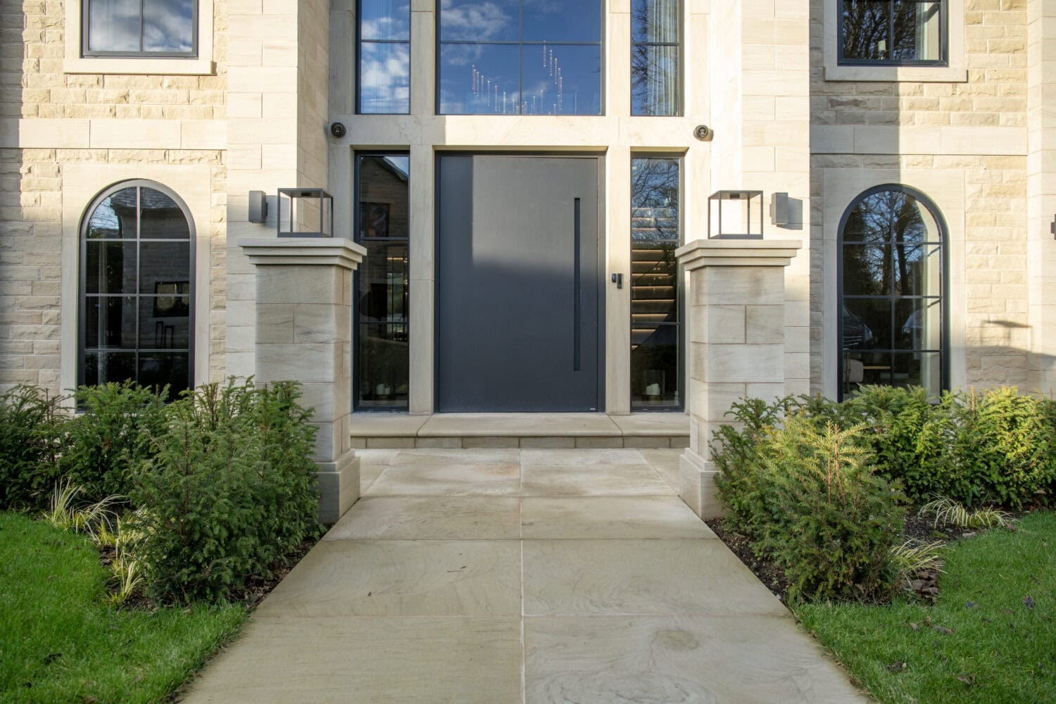 Elegant pivot door with black finish and expansive glass for contemporary home access.