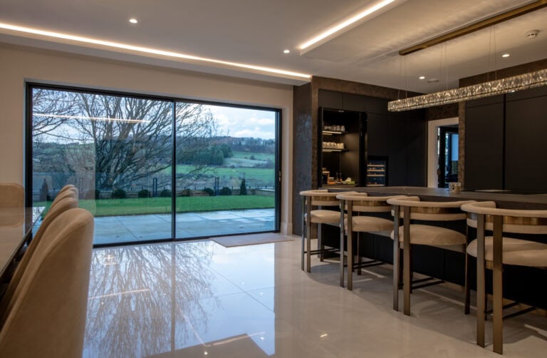 High-quality XP Glide bi-fold doors opening to a scenic outdoor view.