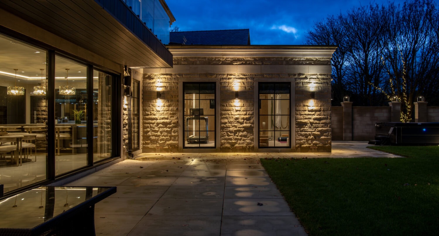 Elegant steel-look bi-fold doors opening to a modern outdoor patio, showcasing sleek design and seamless indoor-outdoor living. Perfect for contemporary homes seeking stylish functionality.