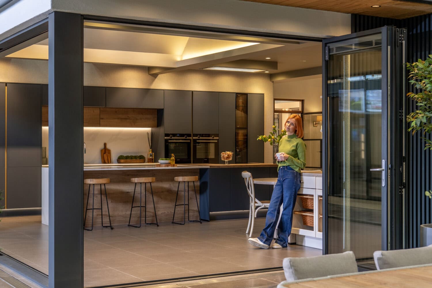 Elegant bi-folding doors opening to a stylish kitchen, showcasing seamless indoor-outdoor living solutions. Perfect for enhancing home aesthetics and functionality.