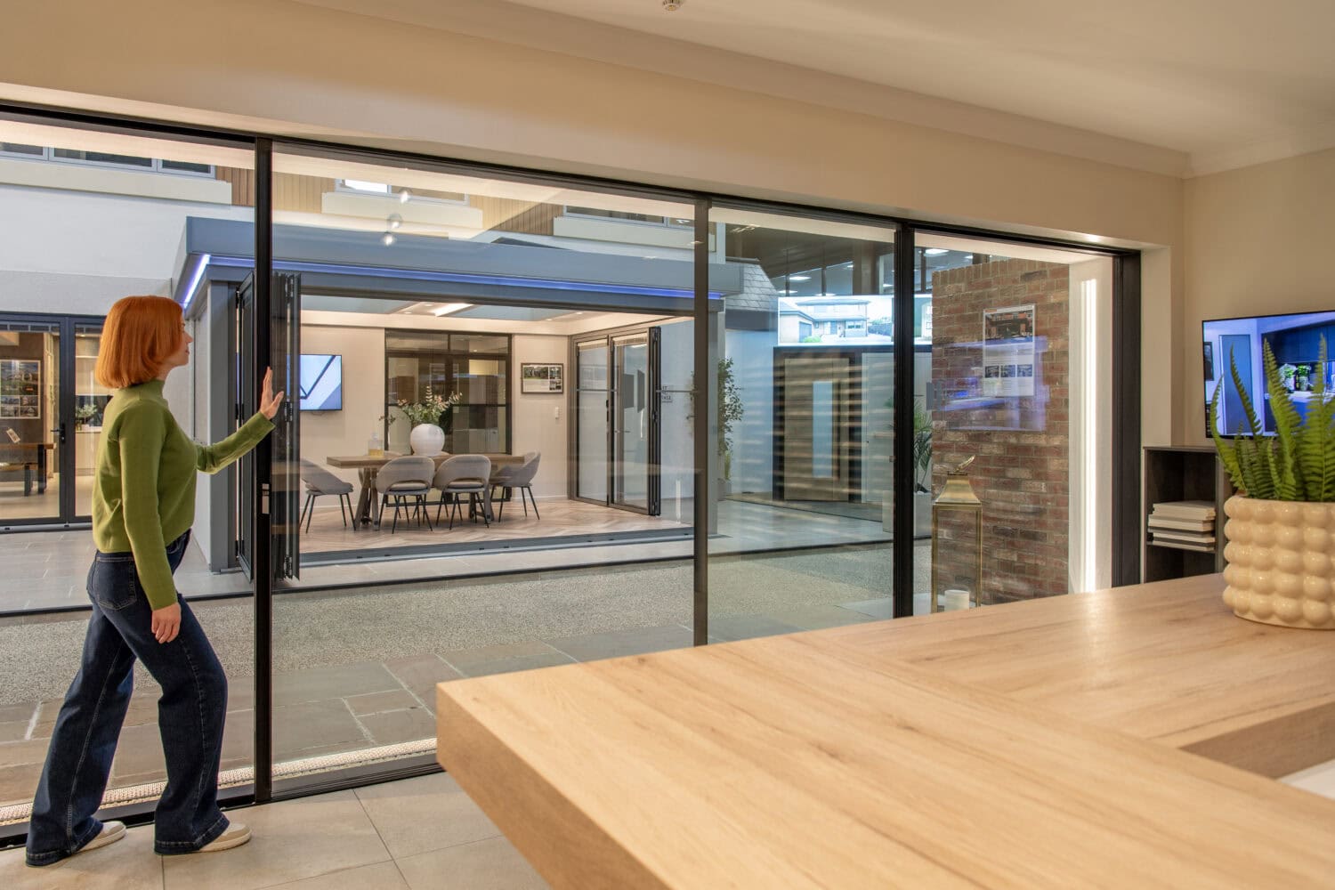 Interior view of modern bi-folding doors opening to an outdoor patio at the new Milton Keynes showroom, showcasing stylish and functional door solutions.