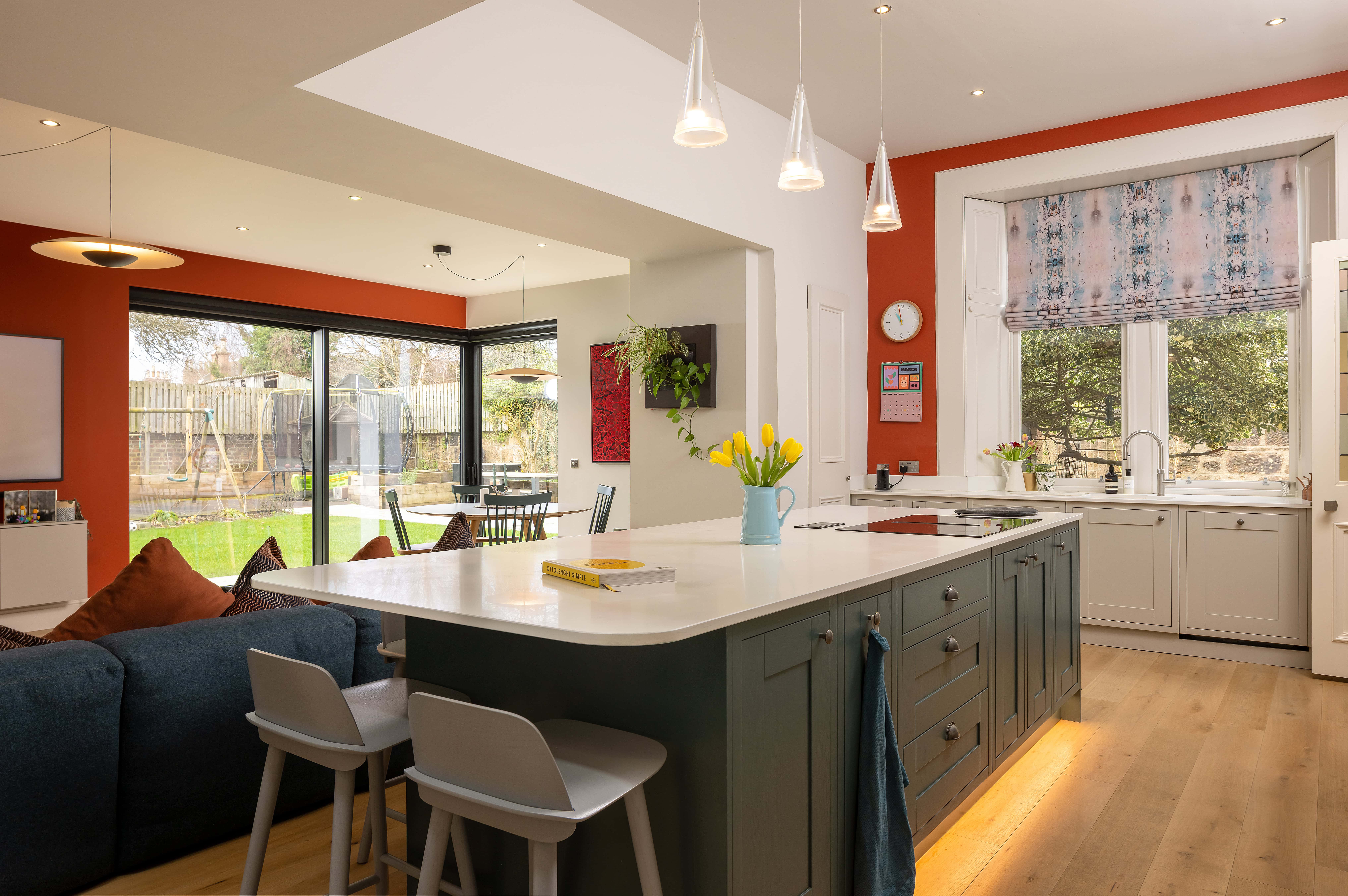 Modern kitchen with a granite worktop, featuring aluminium bi-folding doors, aluminium windows and an aluminium skylight.