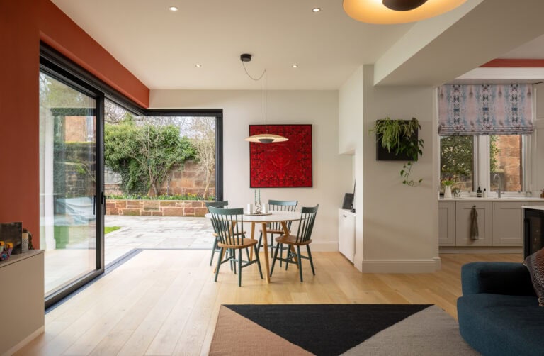 Bi-fold doors opening to garden, bringing natural light into the dining space. Perfect for seamless indoor-outdoor living and enhancing home aesthetics.