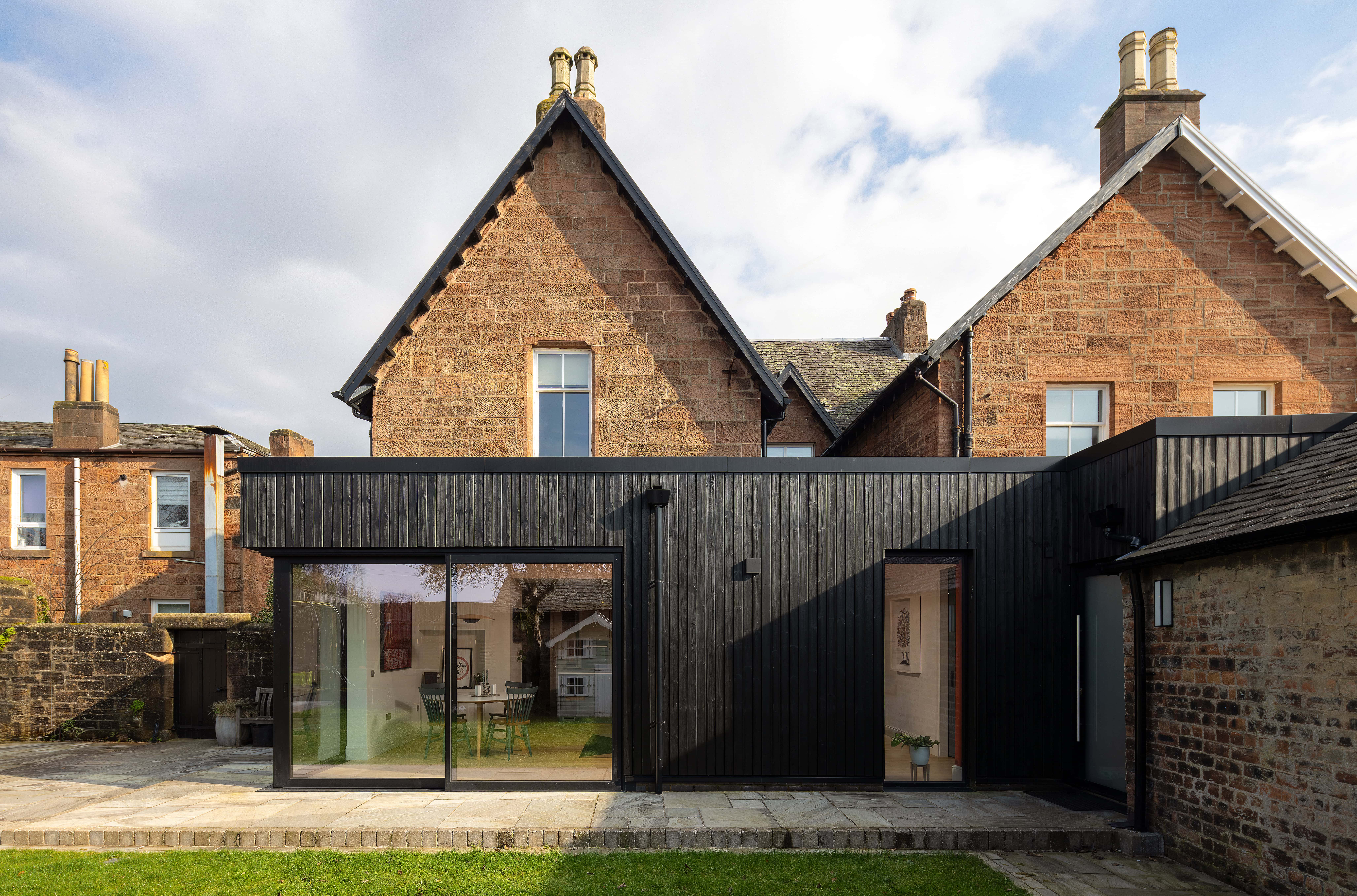 High-quality black bi-folding doors installed at a residential property on Main Street, Uddingston, offering seamless indoor-outdoor transition and enhanced aesthetic appeal.