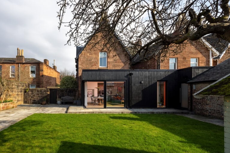 Elegant black bi-folding doors opening to a lush green garden in Main Street, Uddingston, showcasing stylish and functional home improvement with high-quality, energy-efficient design.