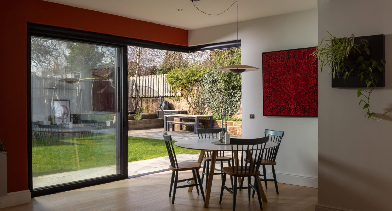 Bright interior featuring large bi-folding doors opening to a garden, showcasing stylish and functional home design in Uddingston.