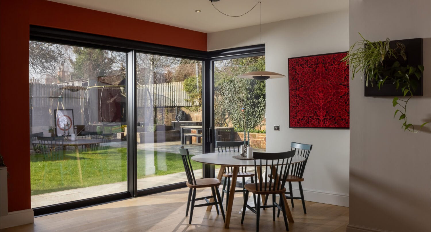 Bright dining area featuring large bi-folding doors opening to a garden, showcasing stylish indoor-outdoor living in Main Street, Uddingston.