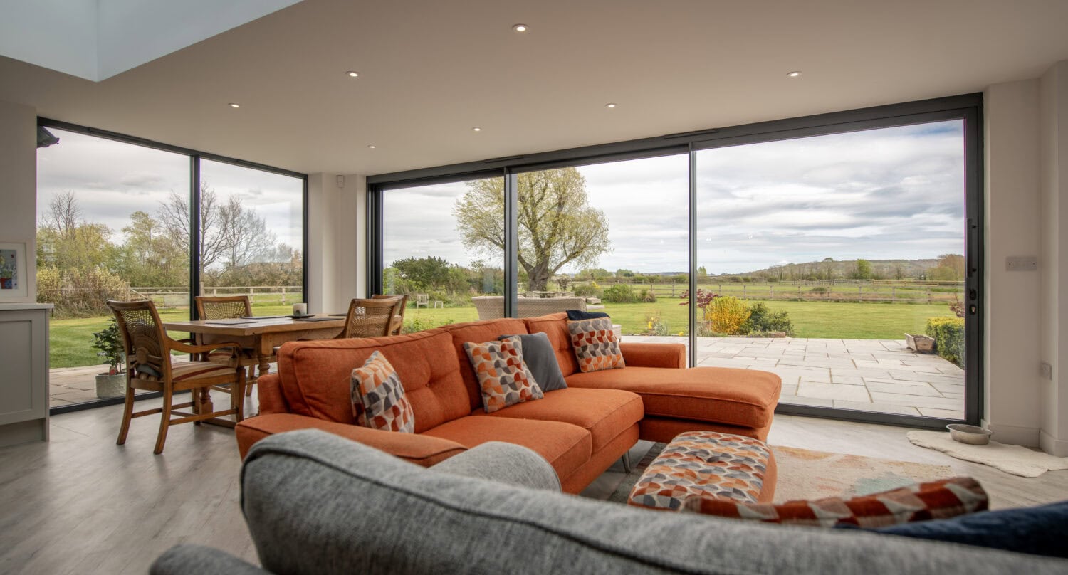 Bi-folding doors opening to scenic countryside views, enhancing natural light and indoor-outdoor living. Perfect for stylish, functional home improvements.