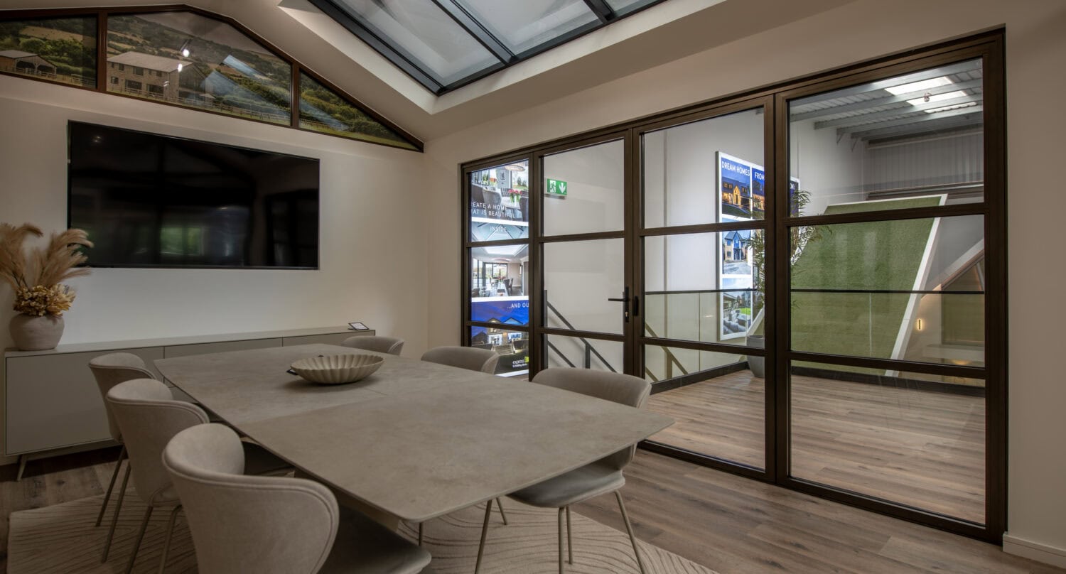 High-quality bi-folding doors displayed in a contemporary showroom with natural light and sleek design, perfect for enhancing home or commercial spaces in Milton Keynes.