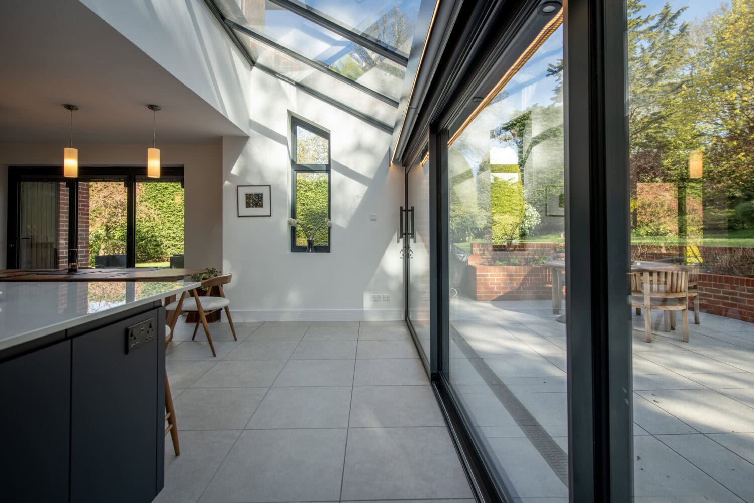 Modern sliding bi-fold doors opening to a bright outdoor patio, enhancing natural light and indoor-outdoor living. Perfect for contemporary home designs.