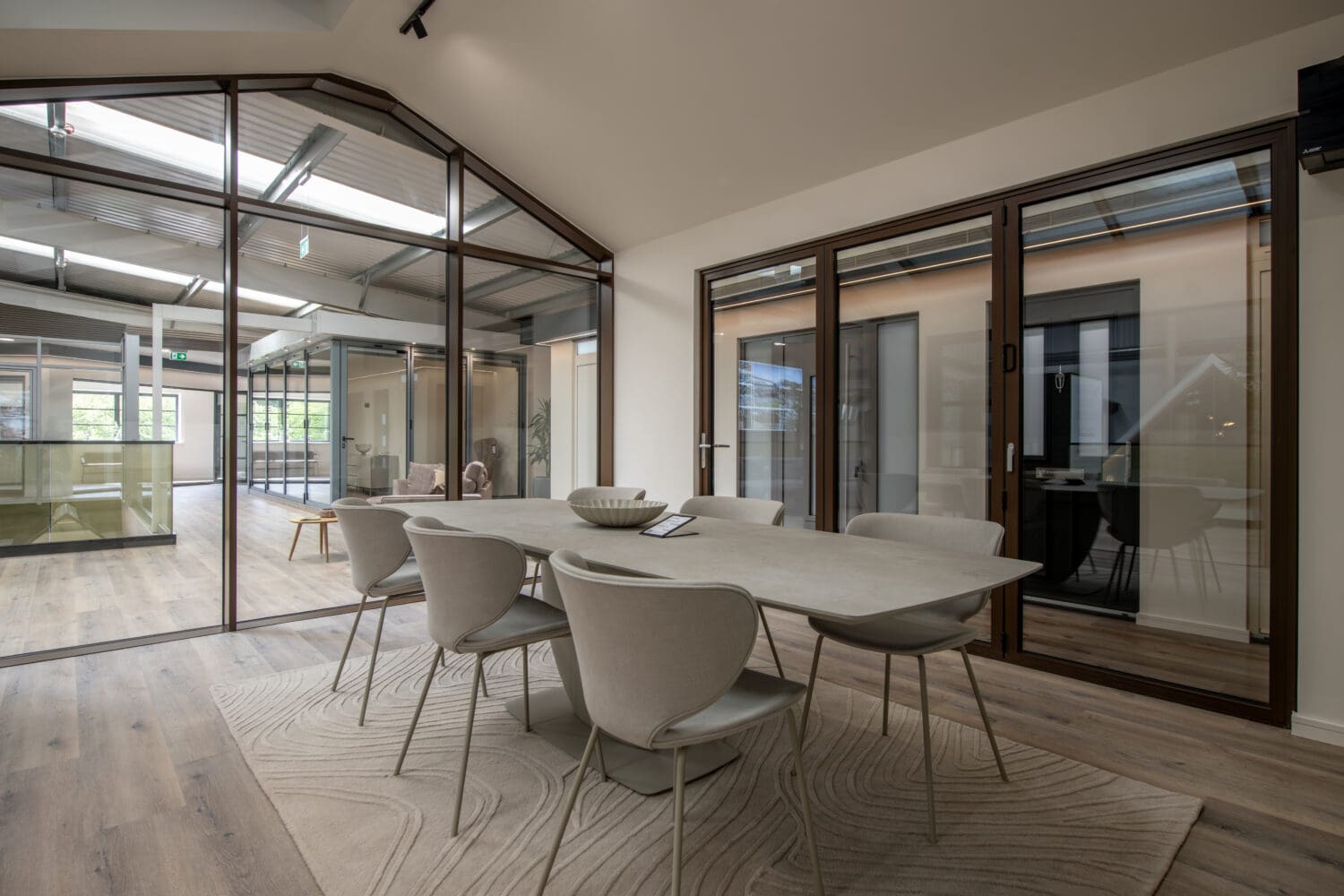 Modern bi-folding doors in a stylish showroom, showcasing seamless indoor-outdoor transition with large glass panels and sleek frames.