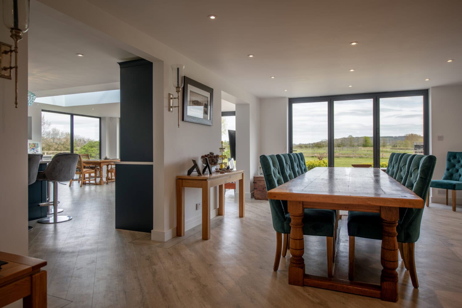 Modern interior with large glass bi-folding doors opening to a scenic outdoor view, showcasing stylish home design and natural light.