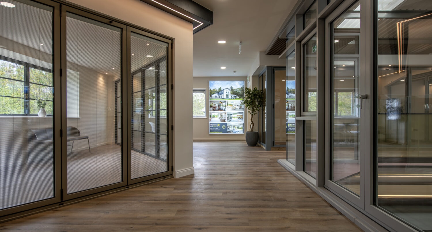 Interior view of modern bi-folding doors at Express Bi-Folding Doors' Milton Keynes showroom, showcasing sleek designs and high-quality glass panels for seamless indoor-outdoor living.