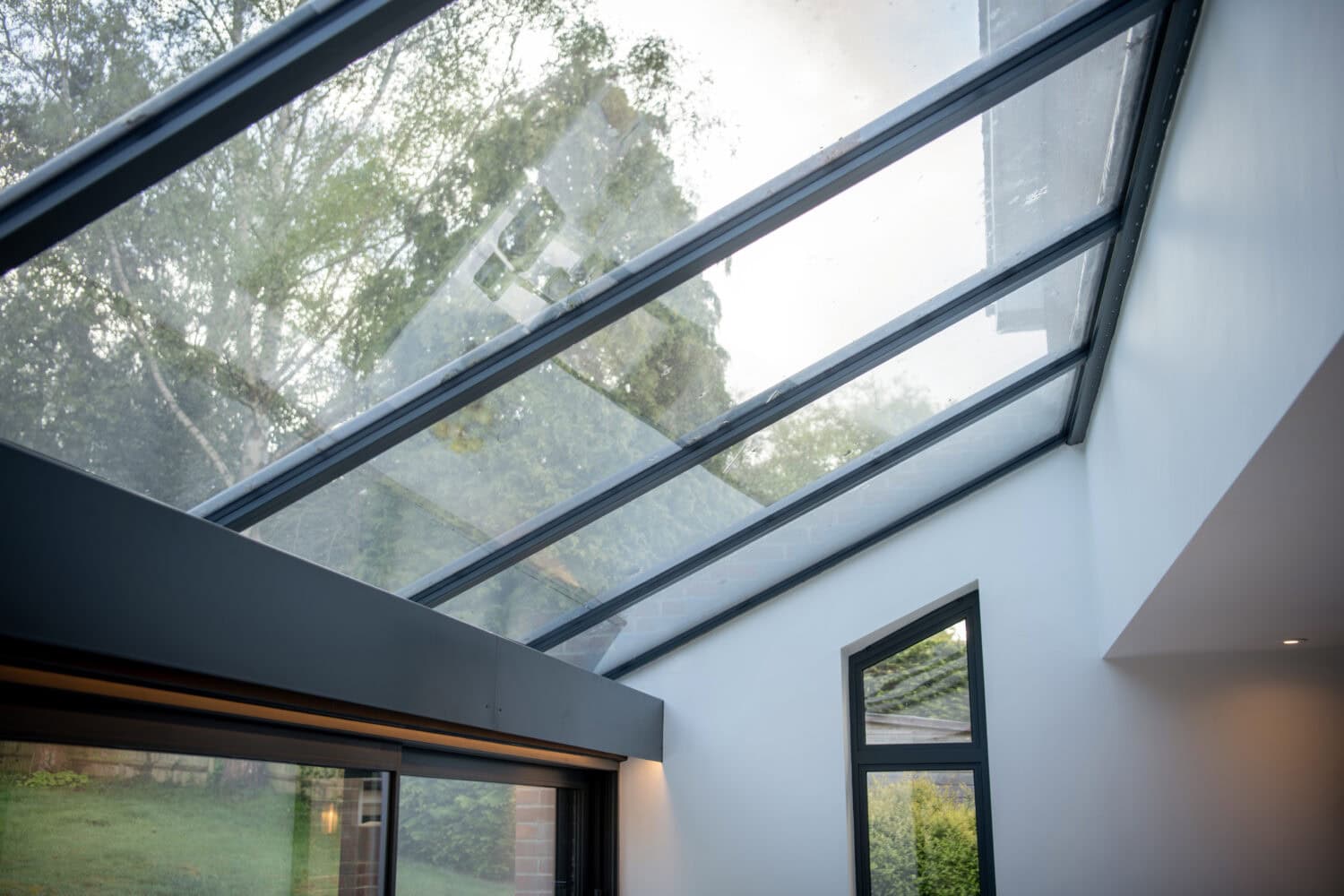 High-quality glass bi-folding doors opening to a garden, providing natural light and seamless indoor-outdoor living. Perfect for contemporary homes and extensions.