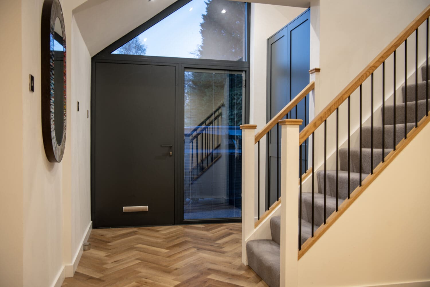 Stylish black bi-folding doors at the entrance of a home, providing a sleek and contemporary look with large glass panels for natural light.
