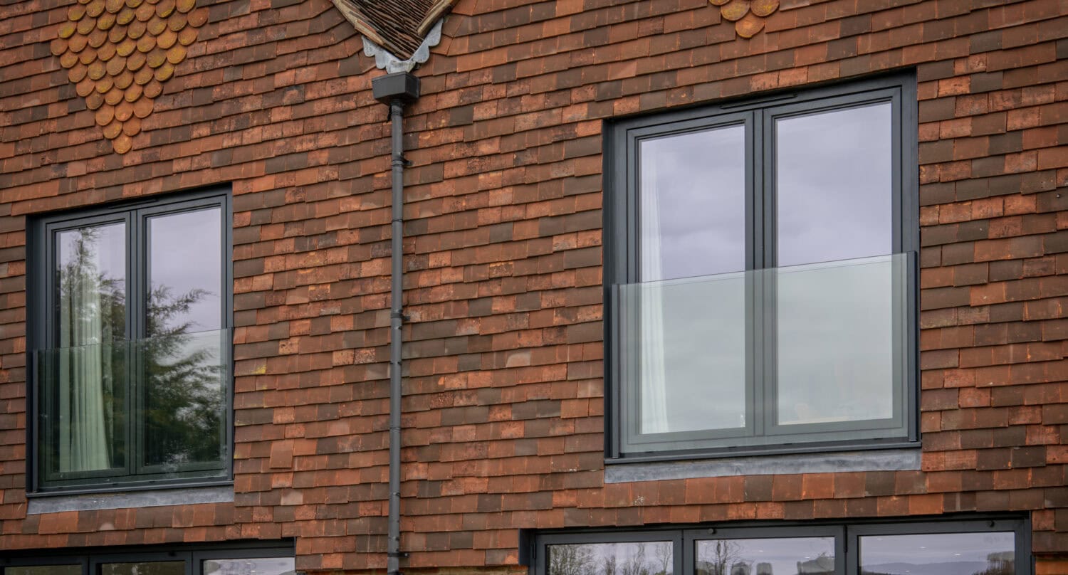 High-quality black framed bi-folding doors installed on a brick house, offering seamless indoor-outdoor transition and enhanced natural light.