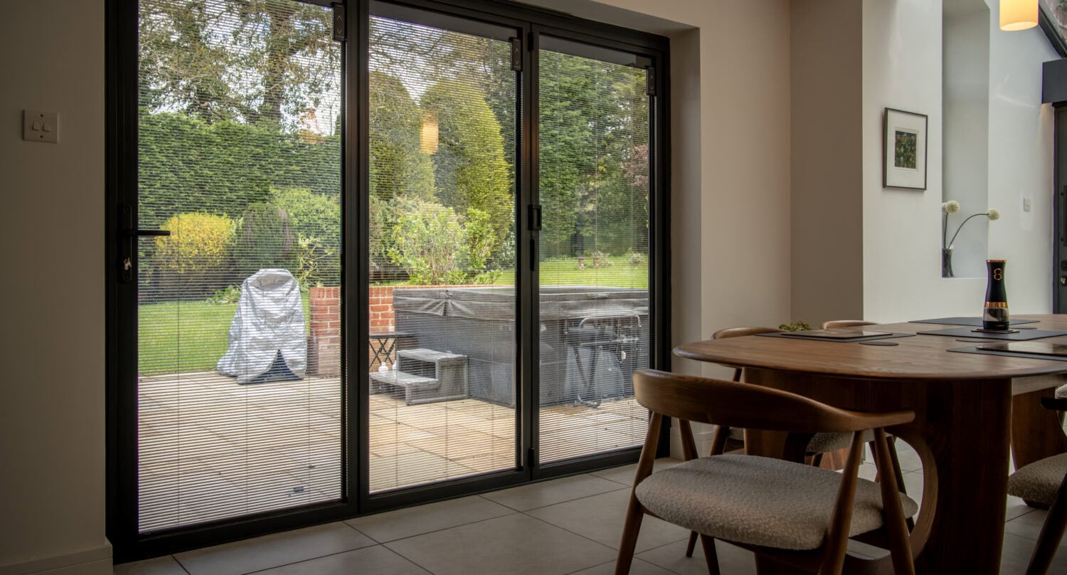 Auto Draft - Express Bi-Folding Doors with large glass panels opening to outdoor patio.