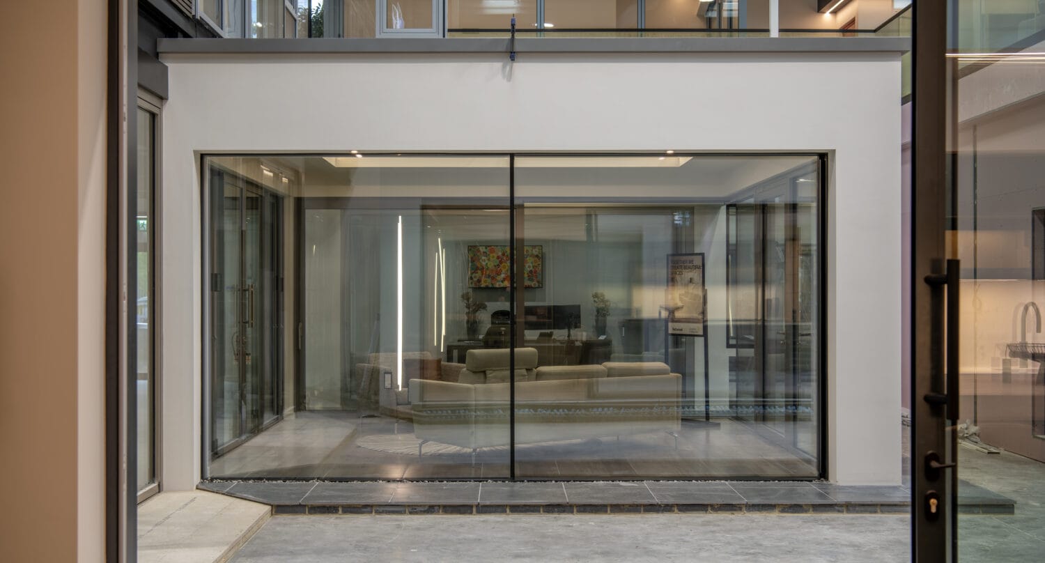 Modern bi-folding doors opening to a stylish interior, showcasing the latest in door design and functionality at Express Bi-Folding Doors' Milton Keynes showroom.
