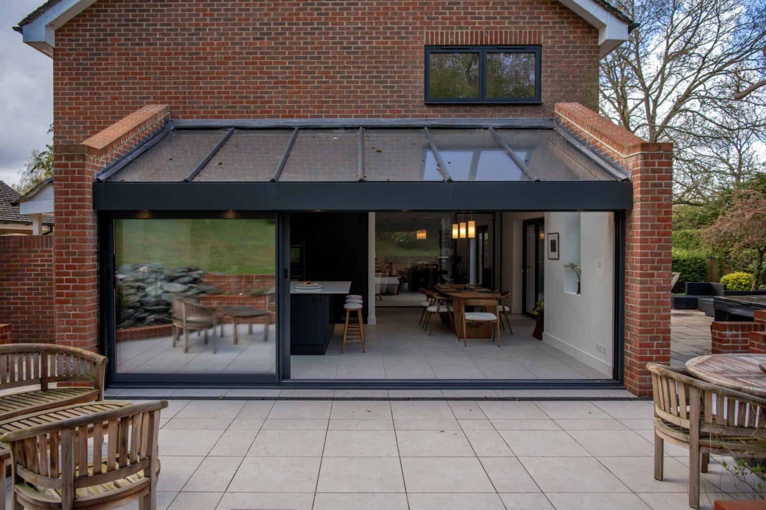 Elegant black bi-folding doors opening to a modern indoor living space, providing seamless indoor-outdoor transition and enhancing natural light in the home. Perfect for contemporary home designs.