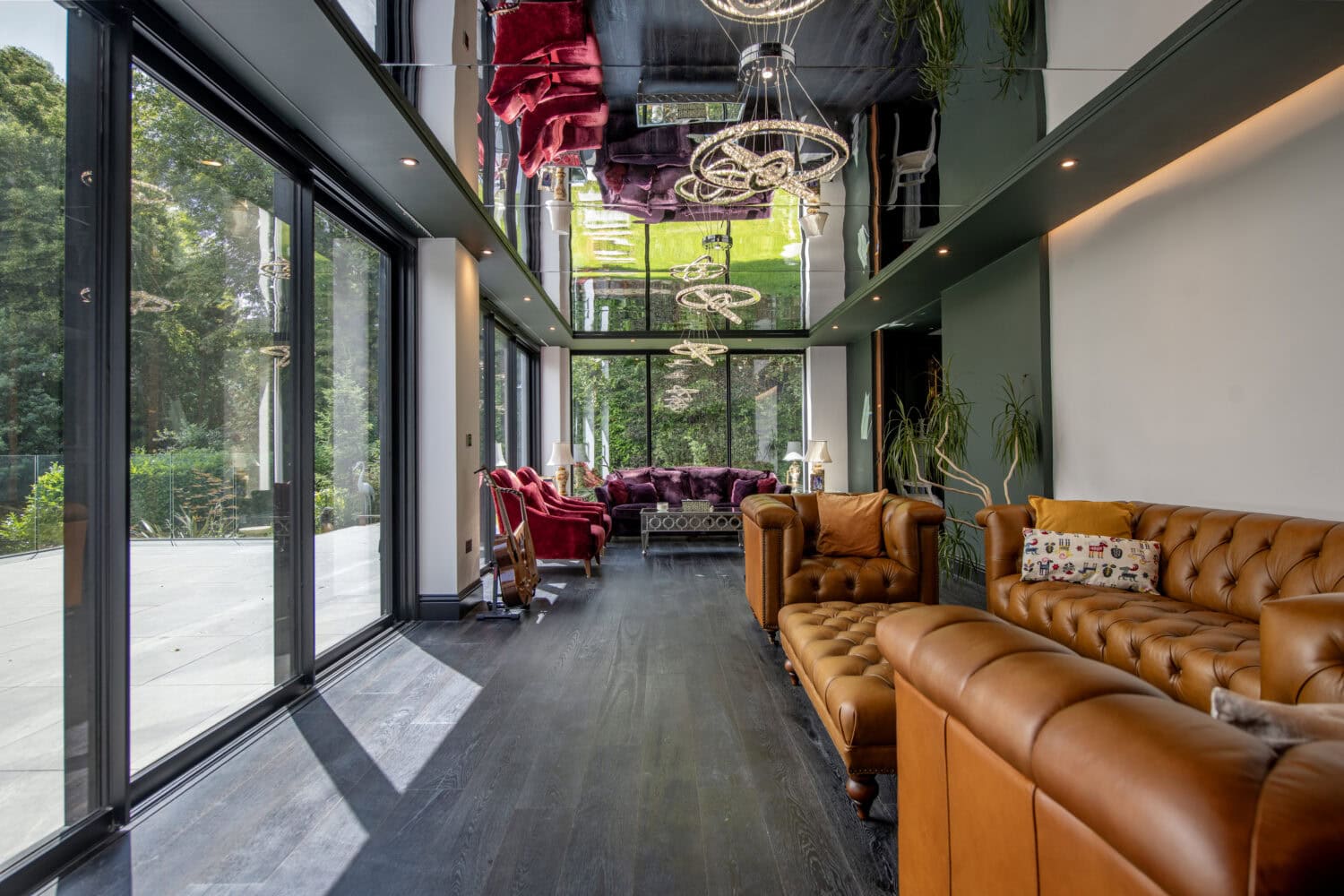Modern interior with large glass bi-fold doors opening to outdoor space, stylish furniture, and contemporary lighting at Stumperlowe Hall.
