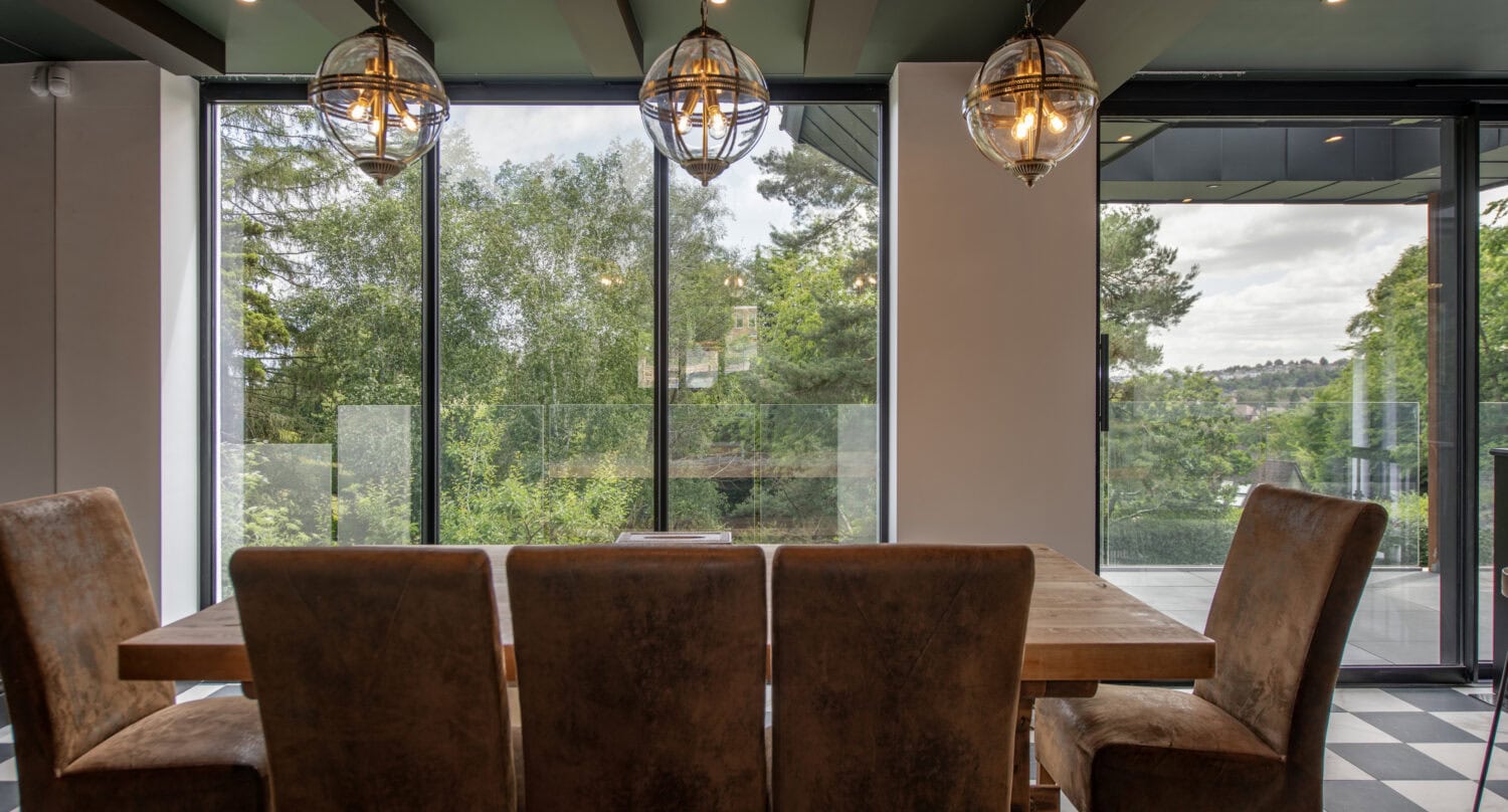 Modern interior with large glass bi-fold doors opening to outdoor greenery, ideal for stylish indoor-outdoor living.