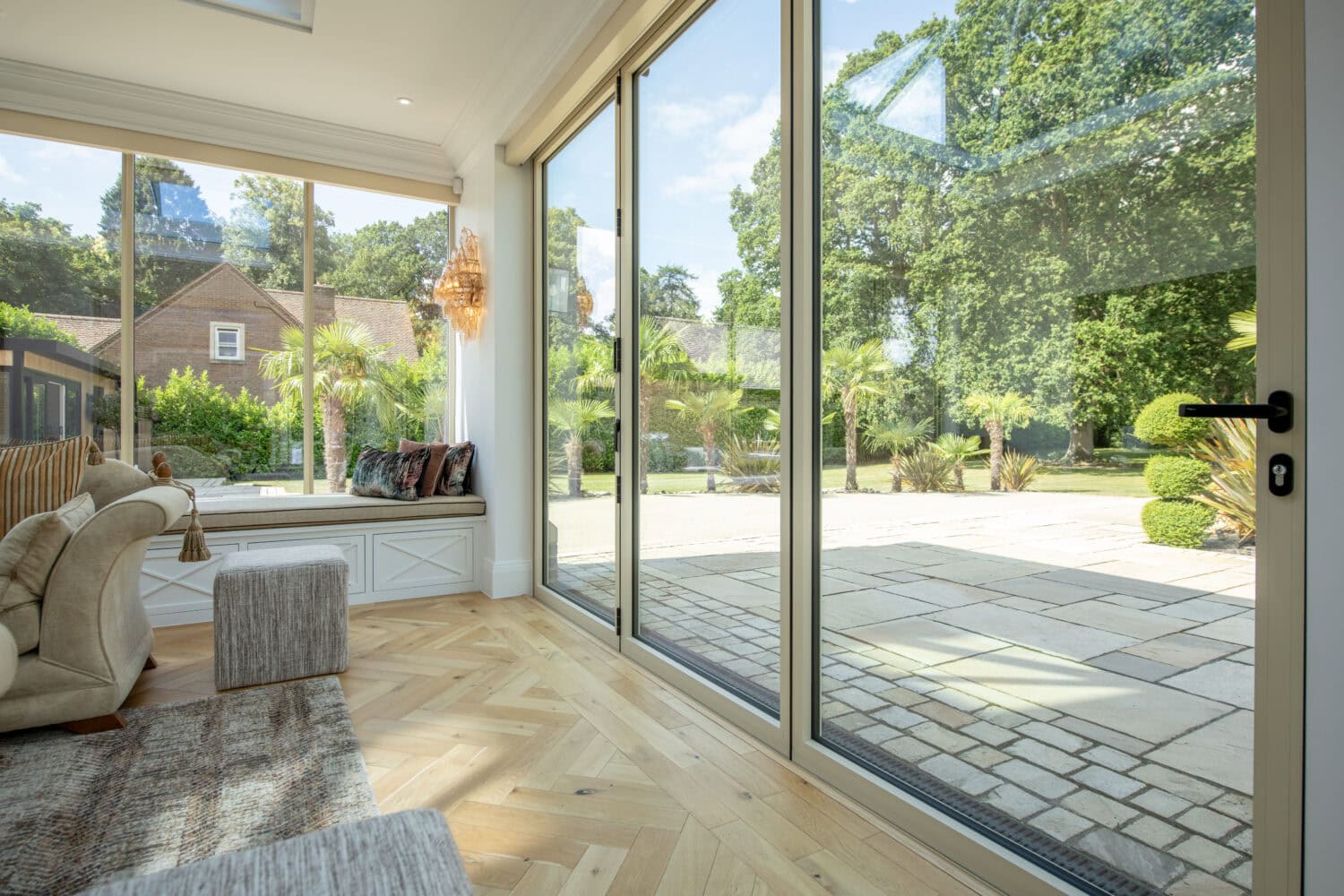 Modern glass bi-folding doors opening to a garden at Foxwood House, providing seamless indoor-outdoor living space.