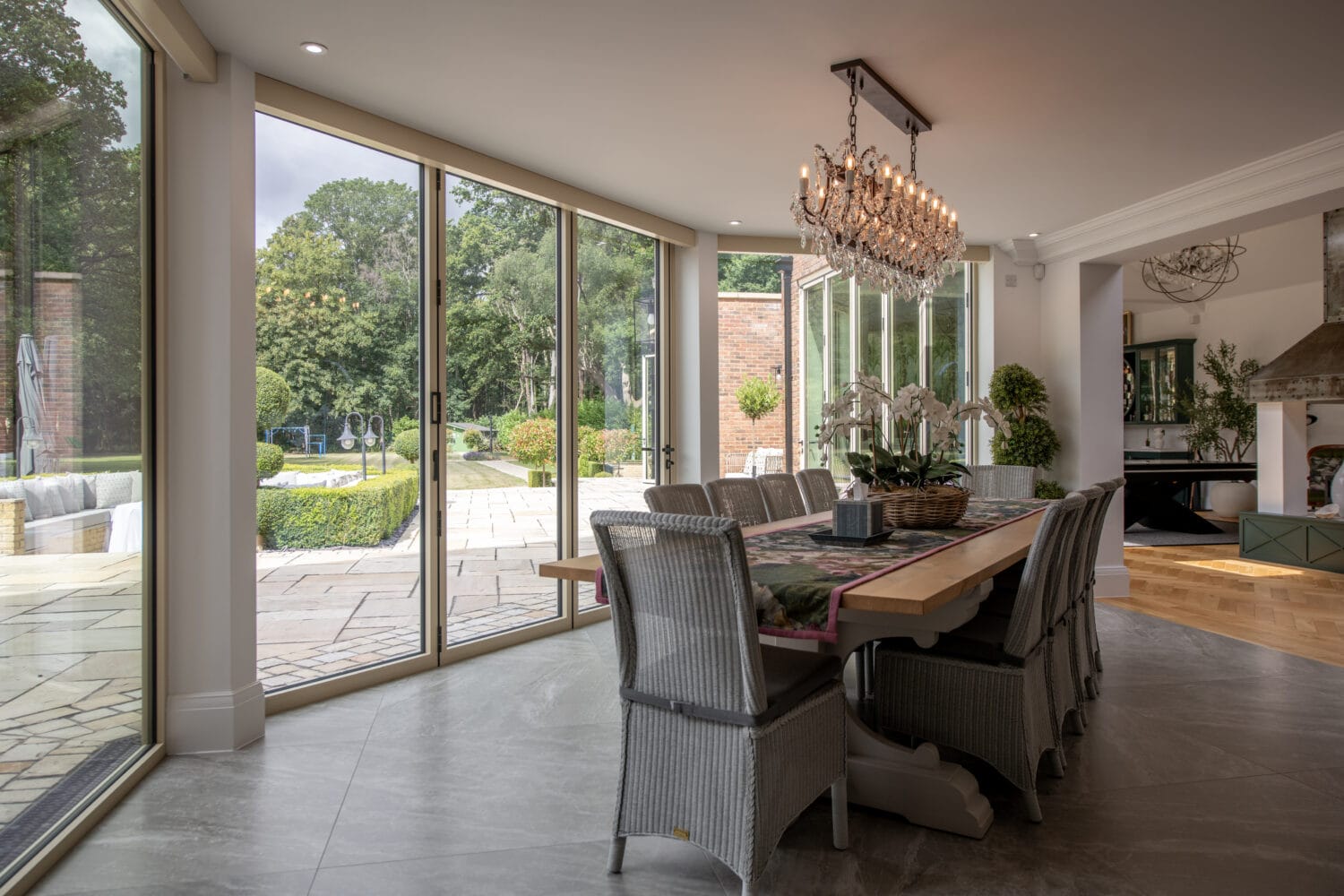 Elegant bi-folding doors opening to a lush garden at Foxwood House, providing seamless indoor-outdoor living space.