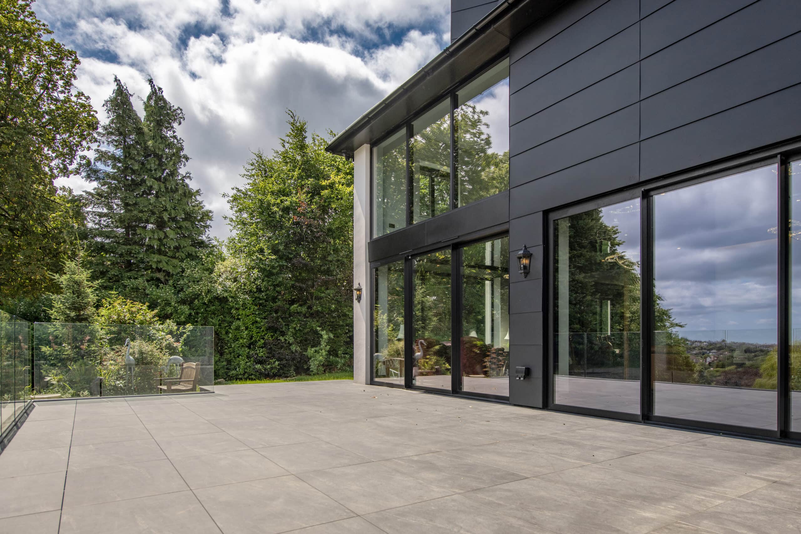 Contemporary bi-folding doors installed at Stumperlowe Hall, offering seamless indoor-outdoor living with large glass panels and sleek black frames.