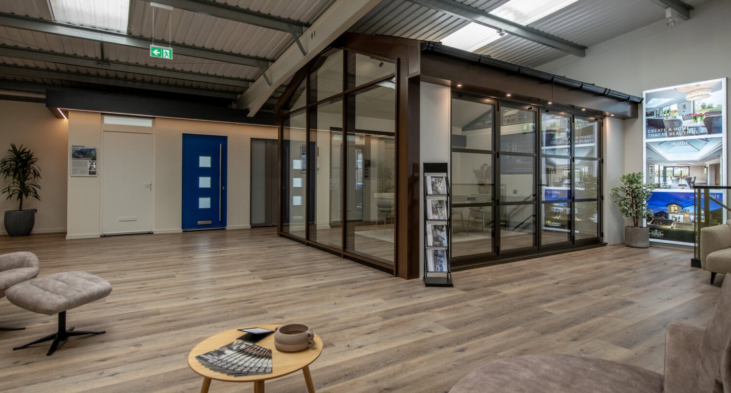 Modern Milton Keynes showroom featuring large bi-folding doors and a spacious interior with wooden flooring and contemporary furniture.