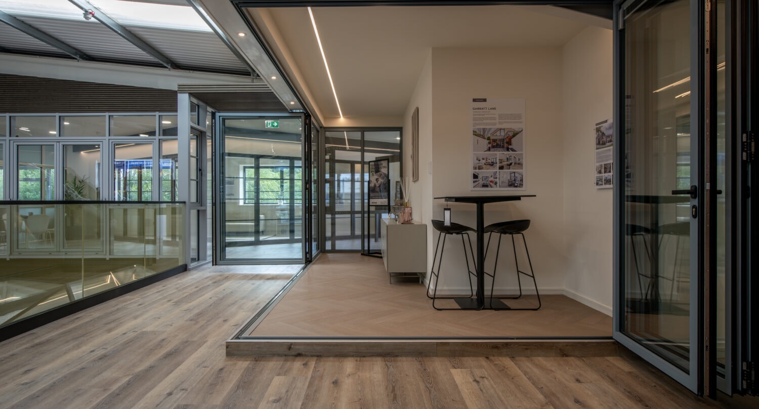 Modern Milton Keynes showroom featuring large bi-folding doors opening to an outdoor space, showcasing stylish interior design and natural light.