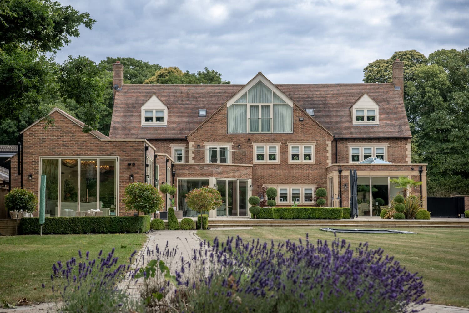 Modern house featuring large bi-folding doors opening to a landscaped garden, showcasing stylish and functional home design.