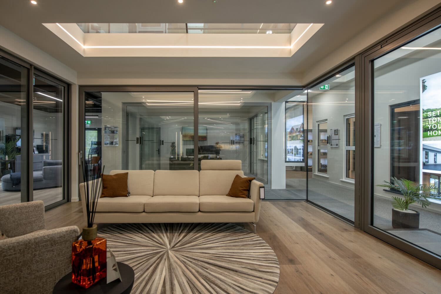 Modern Milton Keynes showroom with bi-fold doors, comfortable seating, and contemporary decor, showcasing high-quality window and door solutions.