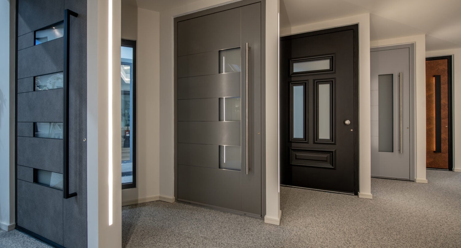 A display of modern bi-folding doors in a showroom, highlighting sleek designs and various finishes for home improvement projects.