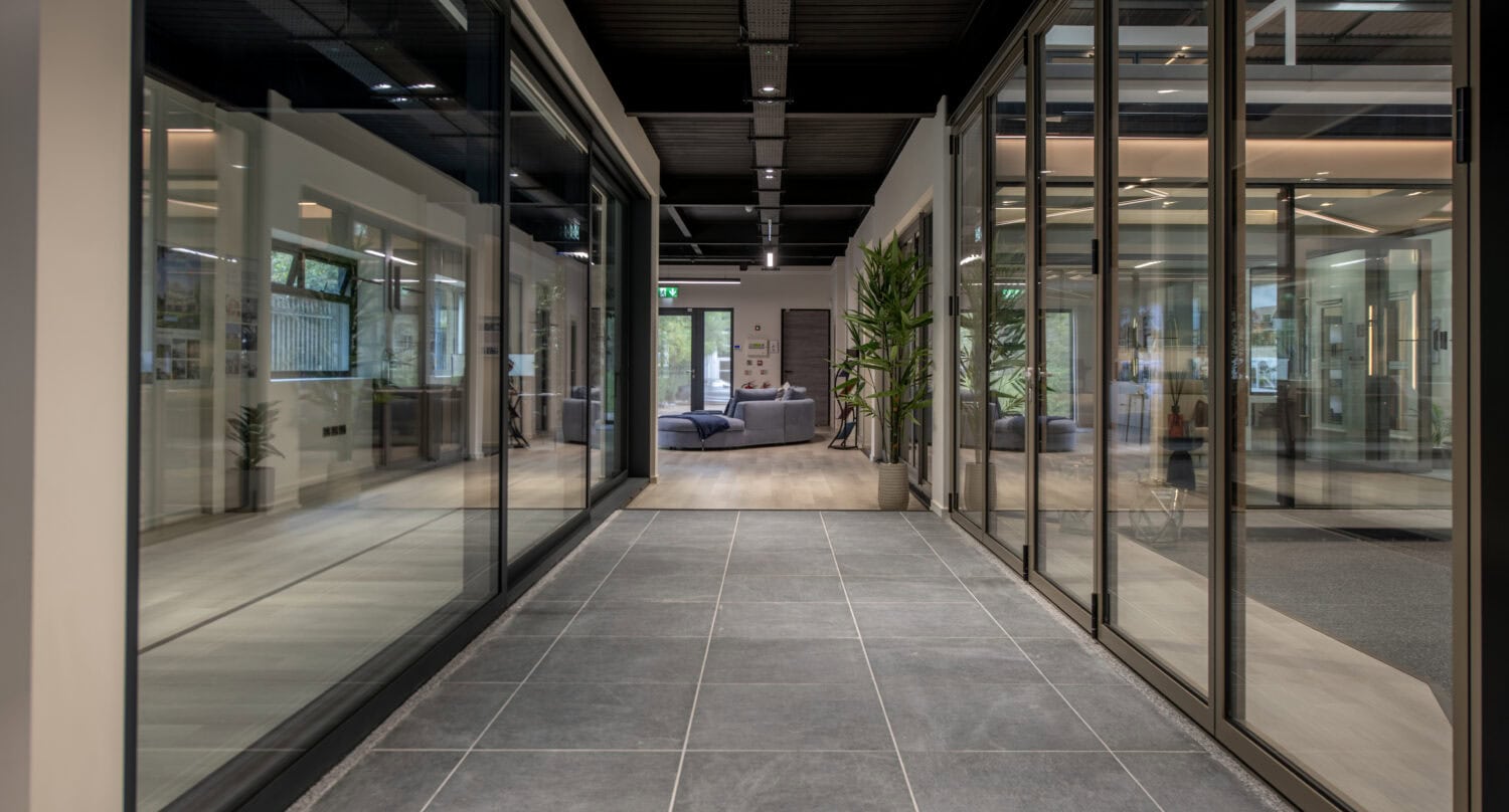 Modern Milton Keynes showroom featuring large glass bi-folding doors and sleek interior design, showcasing high-quality door installations.