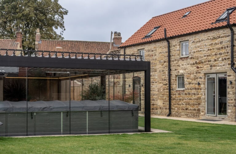 Modern home with large glass bi-folding doors opening to a garden, showcasing stylish and functional outdoor-indoor transition.
