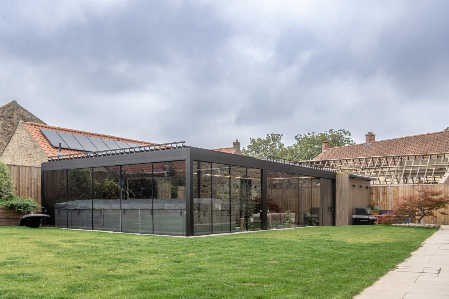 Contemporary bi-folding doors in a sleek black frame opening to a garden, providing seamless indoor-outdoor living space.